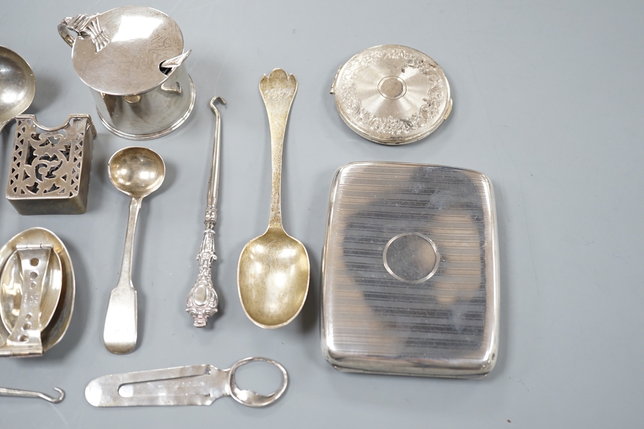 A small collection of sundry silver items including flatware, compact, cigarette case, mustard pot, sterling folding spoon, match sleeve, book mark, cased spoon and fork and a cased Victorian spoon and fork.